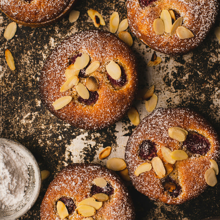 Pequenos bolos com frutos vermelhos, açúcar em pó e amêndoa laminada