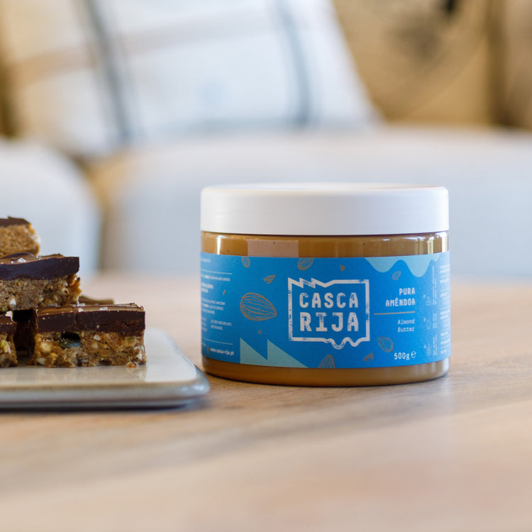 Casca Rija almond butter 500 g beside chocolate-topped bars
