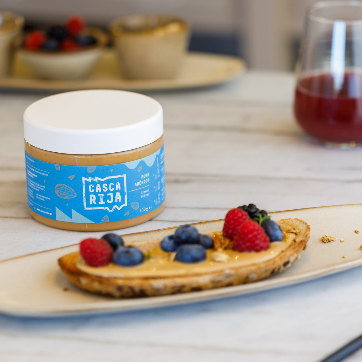 Beurre d’amande Casca Rija 500 g avec des tartines et des fruits rouges