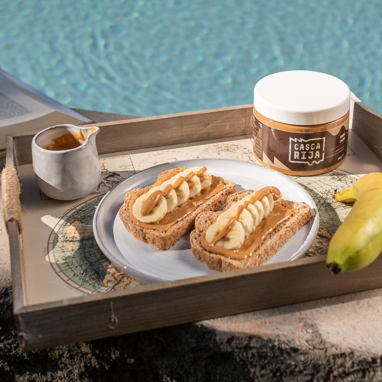 Pão com manteiga de caju e banana junto ao frasco de 500 g na piscina